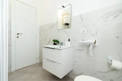 a white bathroom with a toilet and a sink at Domvs Tibvrtina - Solarium Zone, Terrace, A-C, Roma in Rome