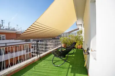 a balcony with a chair and a large umbrella at Domvs Tibvrtina - Solarium Zone, Terrace, A-C, Roma in Rome