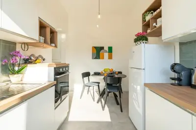 a kitchen with a table and a white refrigerator at Domvs Tibvrtina - Solarium Zone, Terrace, A-C, Roma in Rome