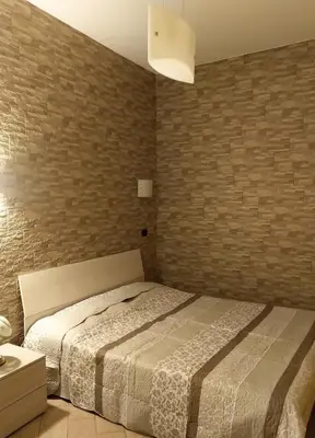 a bedroom with a bed and a brick wall at Casa Carlo in Rome
