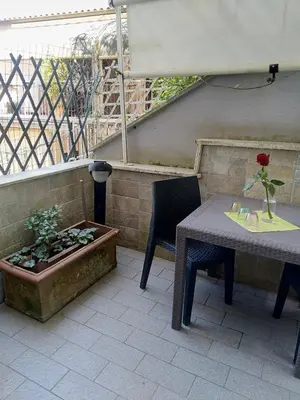 a patio with a table and a plant in a planter at Casa Carlo in Rome