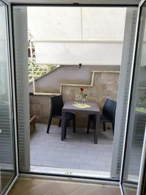 a table with chairs and a vase with a flower on it at Casa Carlo in Rome