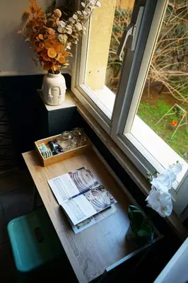 a window sill with a table and a vase with flowers at Stay Smart Termini Esquilino in Rome
