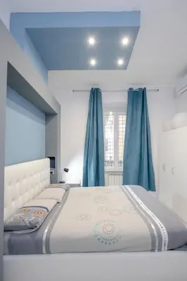 a bedroom with a large bed with blue curtains at Lounge House Vatican - San Pietro in Rome