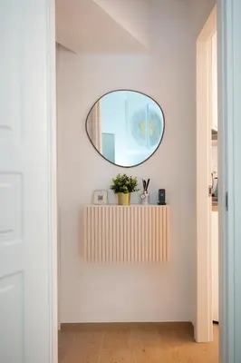 a hallway with a round mirror on a white wall at Sette Chiese Apartment in Rome