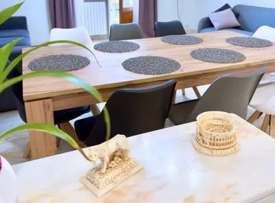 a row of wooden tables with chairs and a plant at Casa vacanze Roma Adelaide's house in Rome