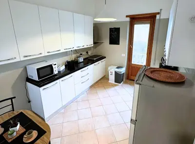 a kitchen with white cabinets and a refrigerator at Casa vacanze Roma Adelaide's house in Rome