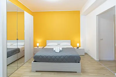 a bedroom with a bed and a yellow wall at Grace's house Roma Trastevere in Rome