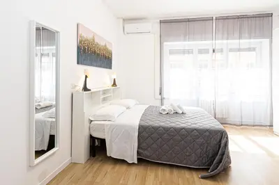 a white bedroom with a bed and a mirror at Grace's house Roma Trastevere in Rome