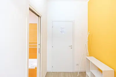 a room with a white door and a yellow wall at Grace's house Roma Trastevere in Rome