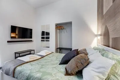 a bedroom with a bed with pillows and a television at BDC - Majestic 4-Bdr in Termini in Rome