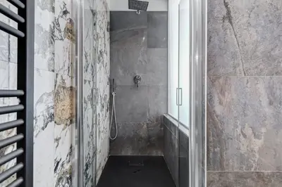 a bathroom with a shower with a glass door at BDC - Majestic 4-Bdr in Termini in Rome