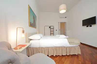 a bedroom with a large white bed and a tv at 4BNB - Giant Giuliana Vatican Museum in Rome