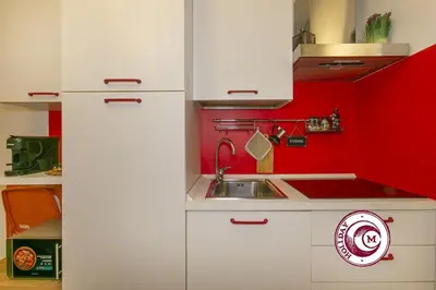 a small kitchen with white cabinets and a sink at La Torre Della Scimmia nido romantico a Piazza Navona in Rome