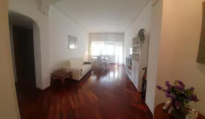 a living room with a white couch and a wooden floor at Holiday apartment in Rome in Rome