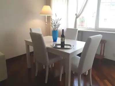 a dining room table with white chairs and a bottle of wine at Holiday apartment in Rome in Rome