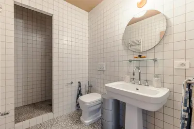 a bathroom with a toilet and a sink and a mirror at Roman Retreat En-suite Room in Rome