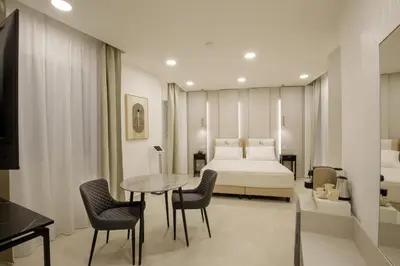 a room with a bed and a table and chairs at Cosmo Vatican Rooms in Rome
