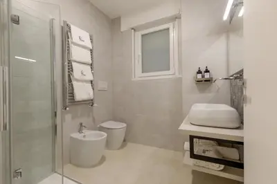 a bathroom with a toilet and a sink and a shower at Cosmo Vatican Rooms in Rome