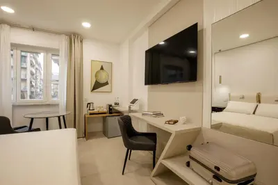 a hotel room with a bed and a desk with a computer at Cosmo Vatican Rooms in Rome