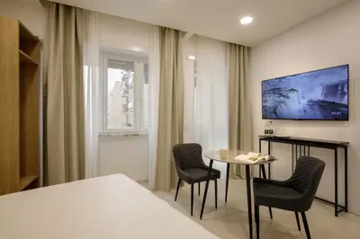 a room with a table and chairs and a tv at Cosmo Vatican Rooms in Rome