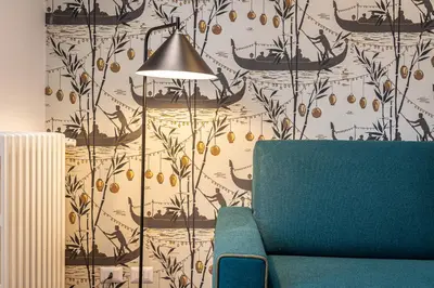 a living room with a couch and a wall with a wallpaper at Amazing Via del Tritone in Rome