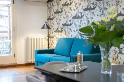 a blue couch in a living room with a table at Amazing Via del Tritone in Rome