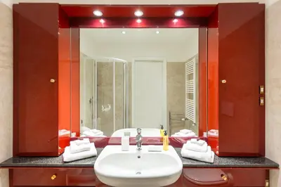 a bathroom with a sink and a large mirror at Amazing Via del Tritone in Rome