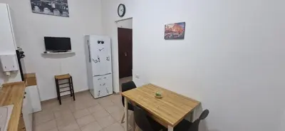 a kitchen with a wooden table and a refrigerator at Casa Nuccia,Close to Vatican city and Gemelli in Rome