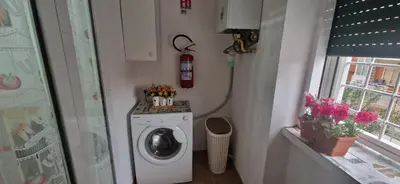 a laundry room with a washing machine and a fire extinguisher at Casa Nuccia,Close to Vatican city and Gemelli in Rome