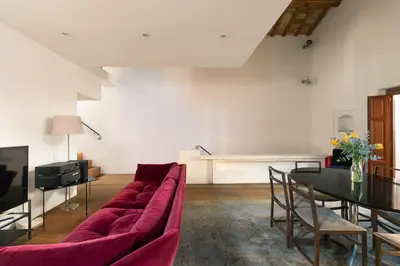 a living room with a red couch and a table at Luce Trastevere Retreat by Romeloft in Rome