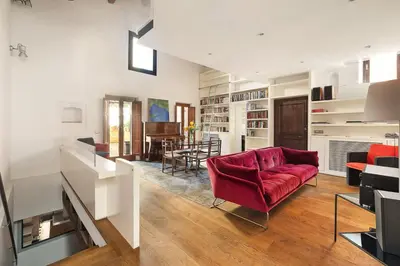 a living room with a red couch and a dining room at Luce Trastevere Retreat by Romeloft in Rome