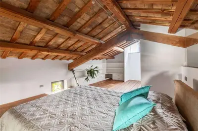 a bedroom with a large bed with blue pillows at Luce Trastevere Retreat by Romeloft in Rome