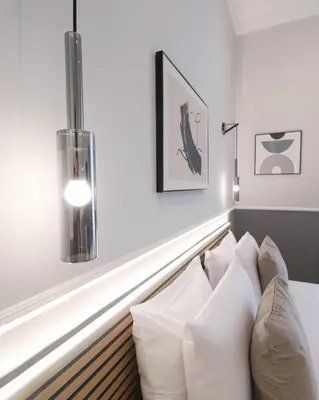 a living room with a couch and a lamp at St Peter & Vatican Luxury Suites - Boutique Suites in Rome Centre & Vatican - AC, Wifi & Metro 5 min in Rome