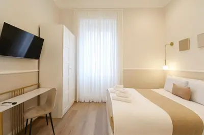 a hotel room with a bed and a desk at St Peter & Vatican Luxury Suites - Boutique Suites in Rome Centre & Vatican - AC, Wifi & Metro 5 min in Rome