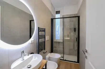 a bathroom with a sink and a toilet and a mirror at St Peter & Vatican Luxury Suites - Boutique Suites in Rome Centre & Vatican - AC, Wifi & Metro 5 min in Rome