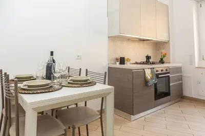 a kitchen with a table with plates and glasses on it at La Casa di Chicca - Musei Vaticani in Rome