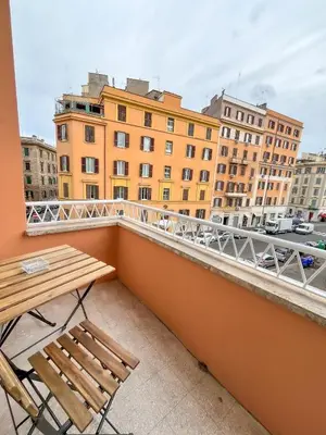 a balcony with a wooden table and chairs and buildings at La Casa di Chicca - Musei Vaticani in Rome