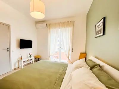 a bedroom with a green bed and a window at La Casa di Chicca - Musei Vaticani in Rome
