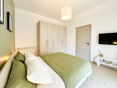 a bedroom with a bed with green and white pillows at La Casa di Chicca - Musei Vaticani in Rome