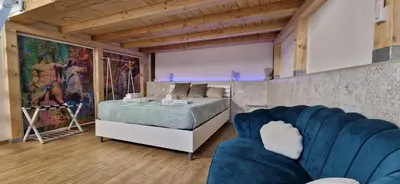 a bedroom with a bed and a blue couch at Luxury AmazingAppiaAntica-Quirinale in Rome