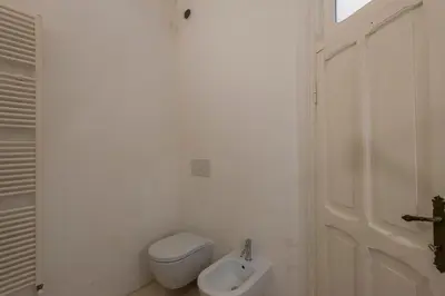 a white bathroom with a toilet and a sink at Vittorio Luxury Panoramic Apartment in Rome
