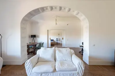 a white couch in a living room with an archway at Vittorio Luxury Panoramic Apartment in Rome