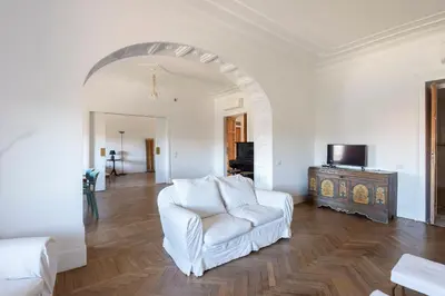 a living room with a white chair and a television at Vittorio Luxury Panoramic Apartment in Rome