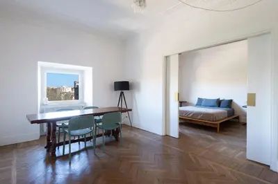 a living room with a table and chairs and a bed at Vittorio Luxury Panoramic Apartment in Rome