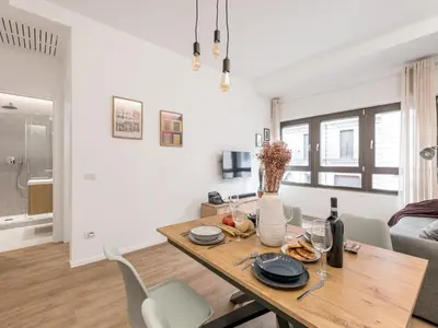 a dining room and living room with a wooden table and chairs at The Best Rent - Spacious Apartment Near Castel Sant’Angelo in Rome