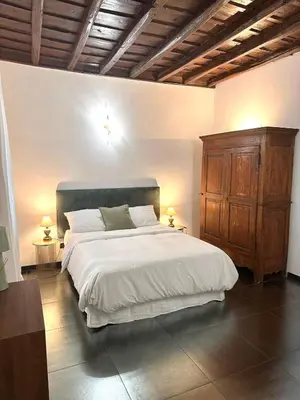 a bedroom with a large bed and a wooden cabinet at Elegant Apartment in Rome's Historic Center in Rome