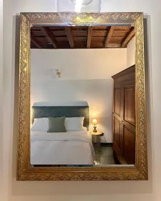 a mirror reflecting a bed in a room at Elegant Apartment in Rome's Historic Center in Rome