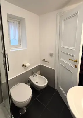 a white bathroom with a toilet and a sink at Elegant Apartment in Rome's Historic Center in Rome