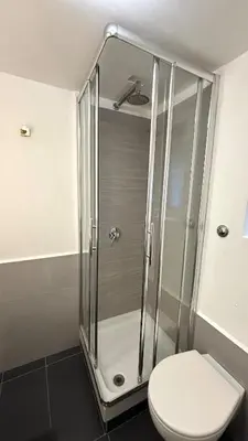 a bathroom with a glass shower with a toilet at Elegant Apartment in Rome's Historic Center in Rome